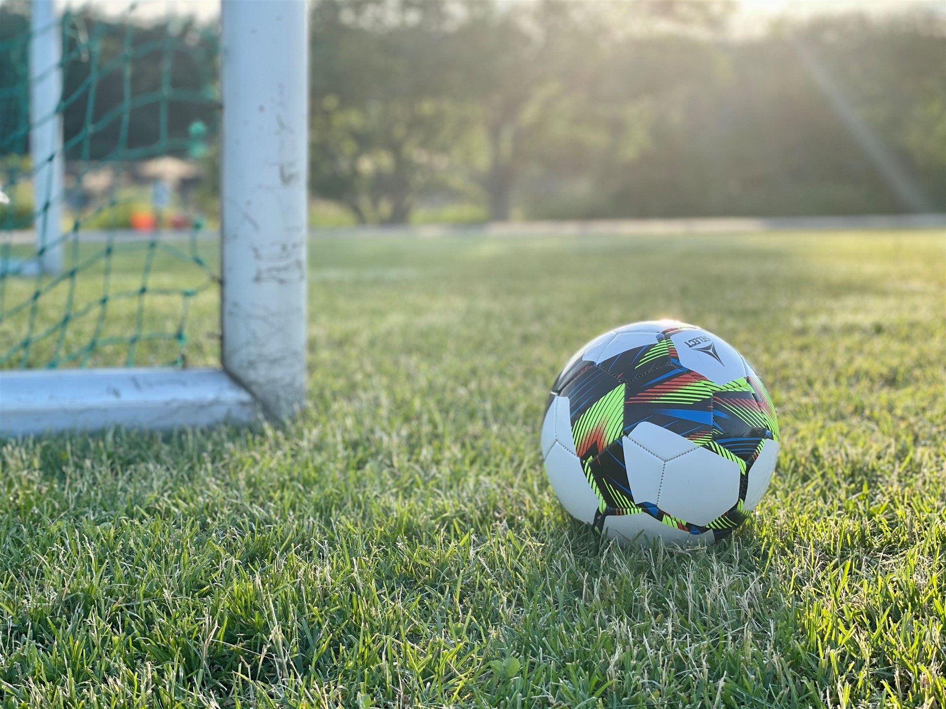 Fotball ved et mål ved solnedgang