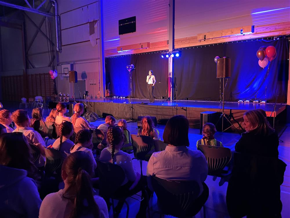 En som opptrer på scenen og publikum som ser på. - Klikk for stort bilde