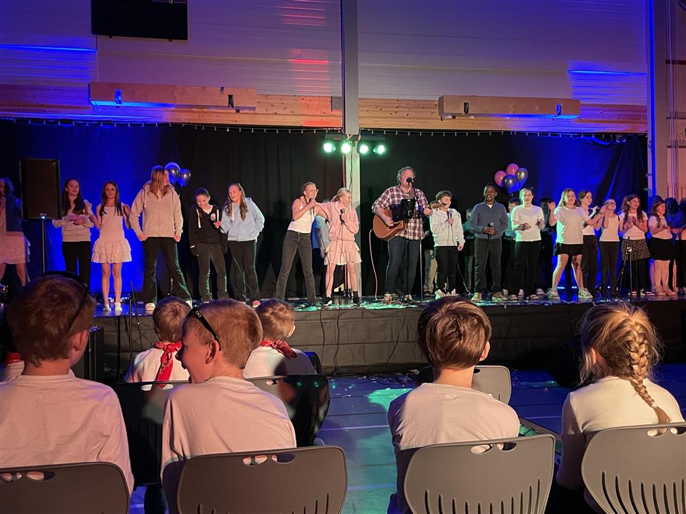 Mange som synger sammen på scenen - Klikk for stort bilde