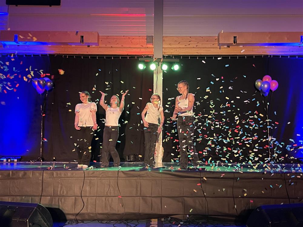 Konfetti på scenen  og jenter som står på scenen - Klikk for stort bilde